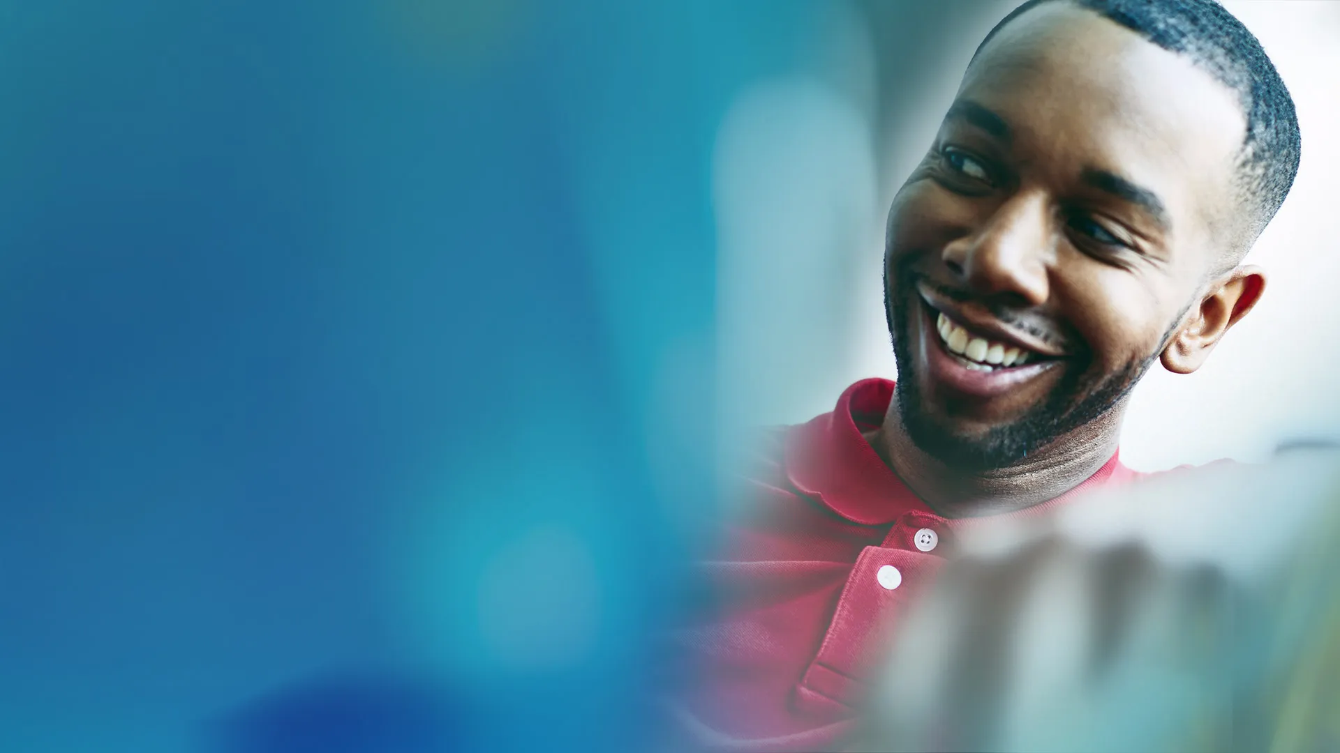 Close-up portrait of a young black change management professional, smiling at work